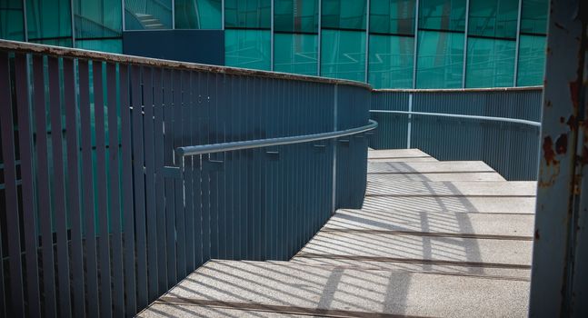 modern public staircase viewed from above descending to a glass building