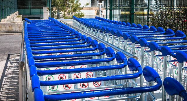 Faro, Portugal - May 3, 2018: carry cart outside Faro international airport available to travelers to move their luggage on a spring day