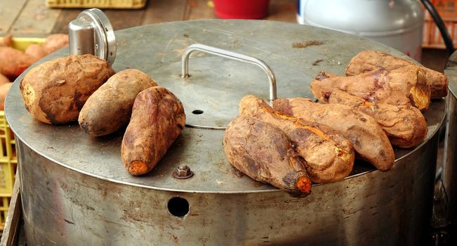 Freshly baked sweet potatoes are kept warm on top of the oven
