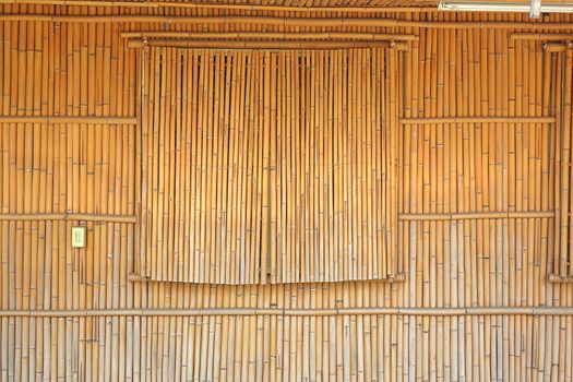 The wall and window shutters of a house are made from bamboo poles
