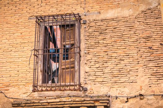 window protect from rusty metal bar on the brick wall of a ruined building