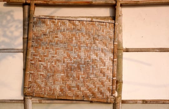 A traditional Chinese farmhouse made from bamboo with a bamboo window cover