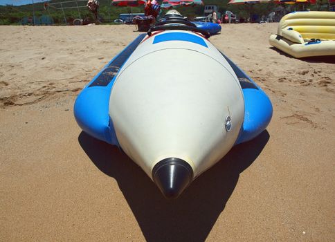 A long banana boat rests on a sand beach