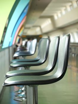 A line of bar stools inside a public building