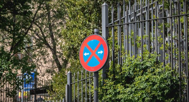 road sign no parking in front of a wrought iron gate in Spain