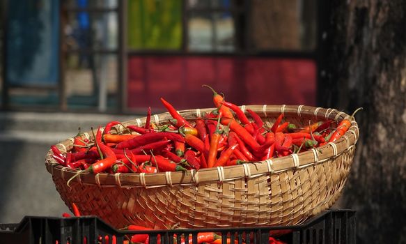 A basket with red hot chili peppers at a local market
