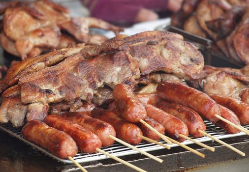 Large slabs of grilled pork and sausages on skewers
