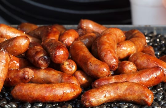 Barbecued sausages are on sale at an outdoor stall