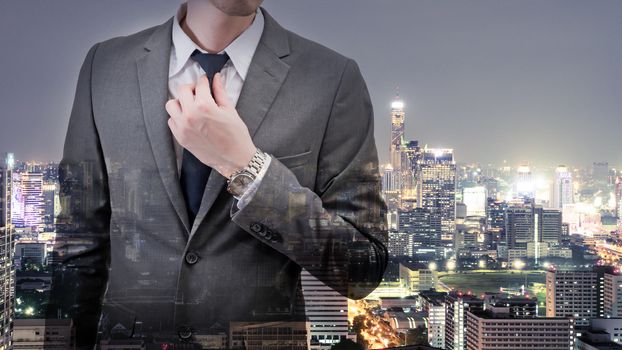 Double exposed of  businessman in gray suit with cityscape at night.