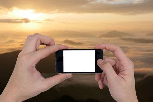 Male hands holding a mobile phone with touch blank white screen on blurred nature landscape background.
