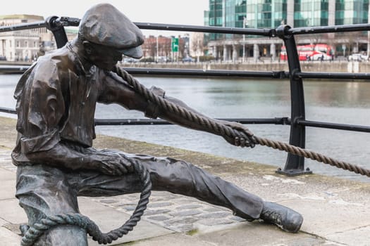 Dublin, Ireland - February 11, 2019: Statue by Dony MacManus of The Linesman on city quay on a winter day