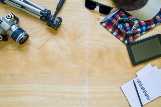 Top view of clothing and diverse personal accessory on the wooden table background.