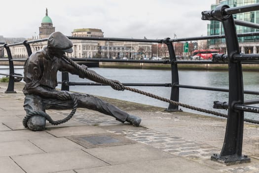 Dublin, Ireland - February 11, 2019: Statue by Dony MacManus of The Linesman on city quay on a winter day