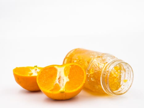 Fresh orange with orange jam in glass jar on white background.