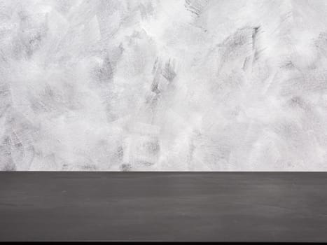 Empty black wooden table on a grunge background.