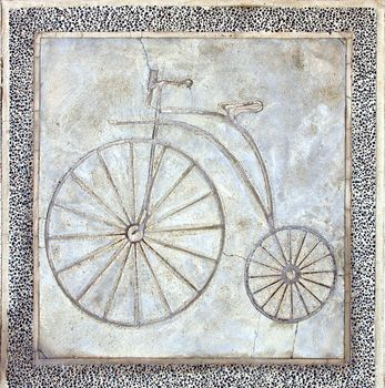 A path for bicycles is marked in concrete with the image of an old style penny-farthing bike
