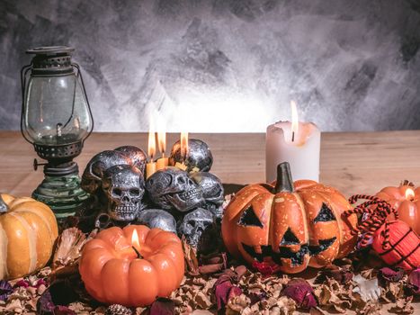 Halloween pumpkins with candlelight and skulls on dark background.