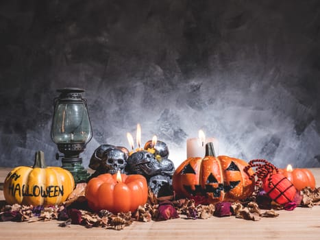 Halloween pumpkins with candlelight and skulls on dark background.