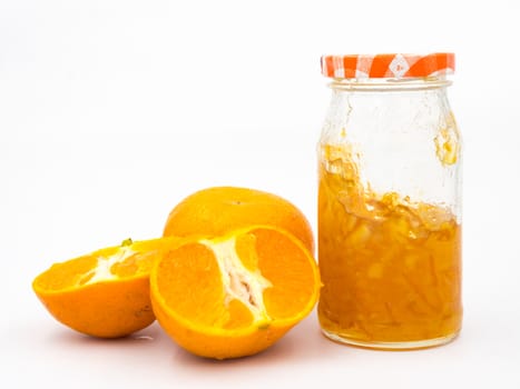 Fresh orange with orange jam in glass jar on white background.