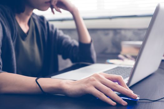 Close up of Casual young woman using a laptop on the desk. Vintage tone