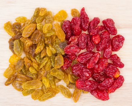 Yellow raisins and Dried Tomatoes on wood background.