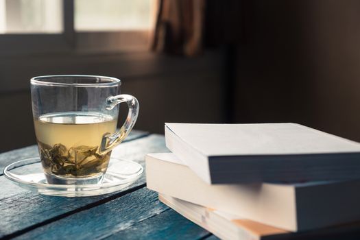 Cup of tea with book on wooden table