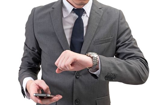 Businessman checking time on his wrist watch and holding mobile phone  isolated on white background.