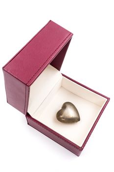 Golden heart in red gift box on white background.