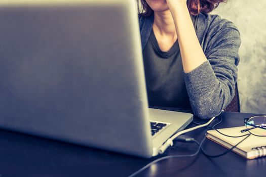 Close up of Casual young woman using a laptop on the desk. Vintage tone