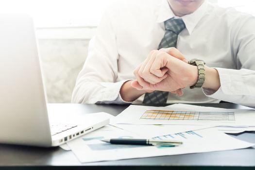 Close up of businessman checking time on his wrist watch.