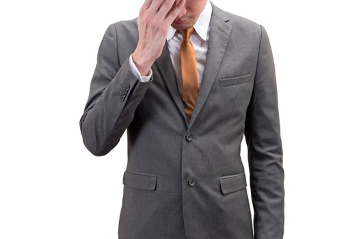 Businessman covering his face with hand isolated on white background.