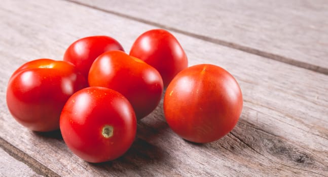 ripe tomatoes on wooden board background in studio
