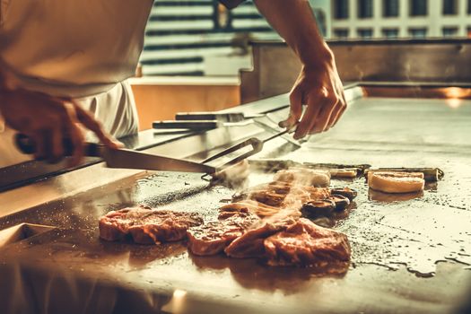 Close up hands chef cooking beef steak and vegetable on hot pan, Japanese food
