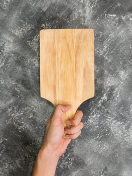 Top view of empty wooden tray with hand on grunge  background.