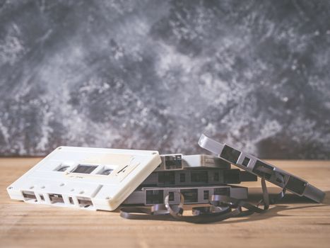 Cassette tapes over wooden table with grunge background. Retro filter.