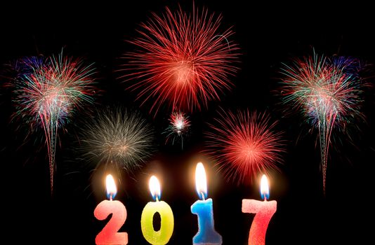 2017 candles numbers on fireworks background. New Year Concept