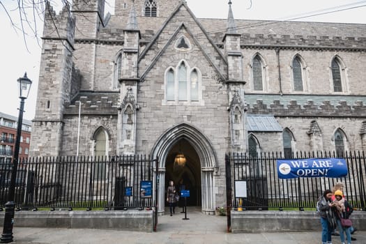 Dublin, Ireland - February 13, 2019: Street atmosphere and architecture of St Patrick's Cathedral that people visit on a winter day