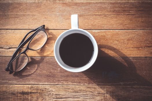 Top view of Coffee cup with Glasses on wooden table background.