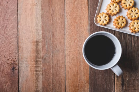 Top view of Cookie and coffee cup on wooden table background. Free space for text