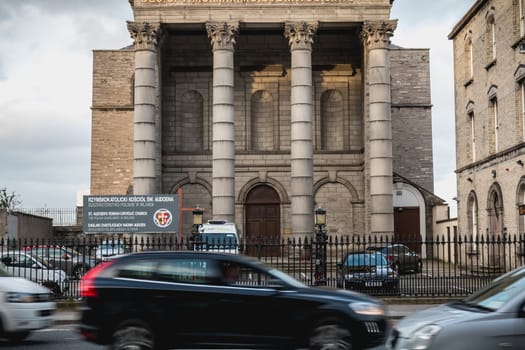 Dublin, Ireland - February 13, 2019: Street atmosphere and architecture of St. Audoen's Roman Catholic Church that people visit on a winter day