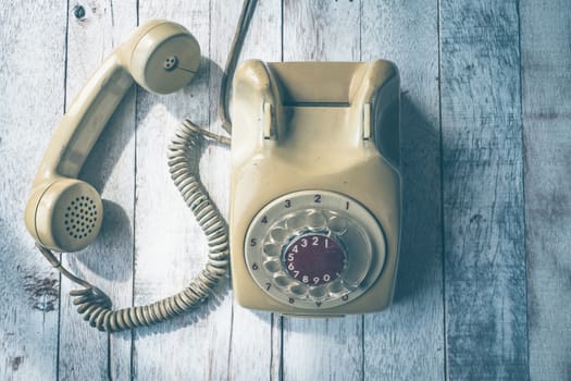 Top view of Old telephone on wooden table background, Vintage tone