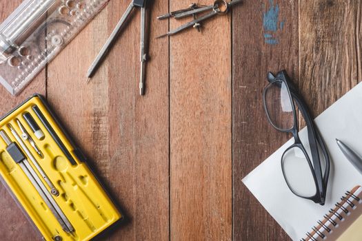 Top view of engineering tools with paper,pen and glasses on wooden table background. Free space for text