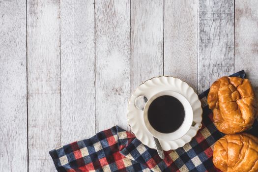 Top view of Coffee cup with bread and tablecloth on wooden table background, Free space for text