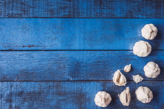 Top view of  Garlic on blue wooden table background.