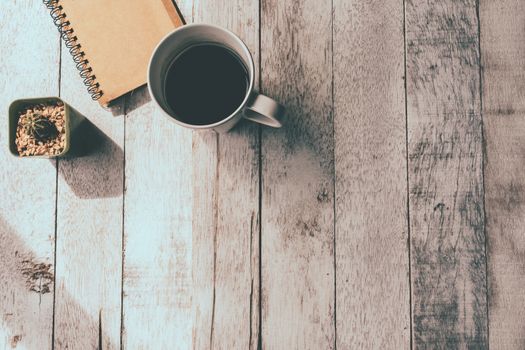 Top view of Coffee cup with notebook and cactus on white wooden table background, Vintage tone, Free space for text