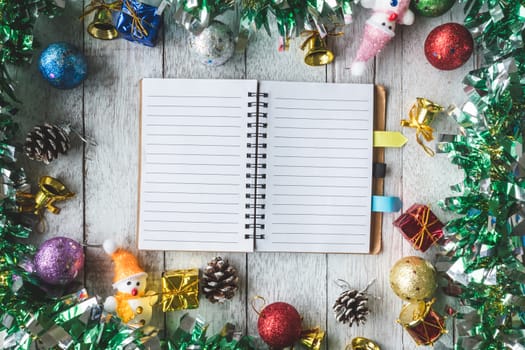 Top view of Notebook with Christmas decoration on white wooden table background