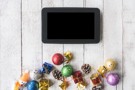 Top view of Tablet with Christmas decoration on white wooden table background