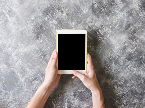 Top view of Male hands using Tablet on grunge gray background.