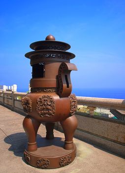 A massive bronze incense burner on a terrace outside a Chinese temple