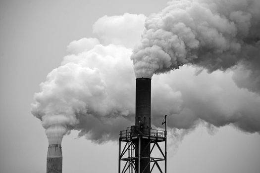 Two factory smoke stacks in black and white